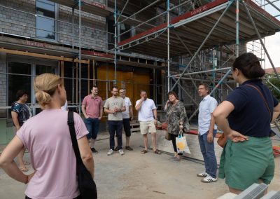 Am Tag des offenen Reallabors bestand die Möglichkeit, die im Bau befindlichen Traumhäuser zu besichtigen: Niedrigenergiestandard, Holz-Hybrid-Bauweise, Schindelfassade, PV-Anlagen, Wärmepumpen, Ladestationen, eingebettet in das Smart East Energiemanagement (Foto FZI Jerome Nguyen)